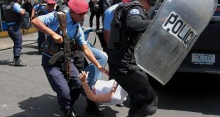 policías agrediendo a universitario por participar en manifestaciones pasivas.
