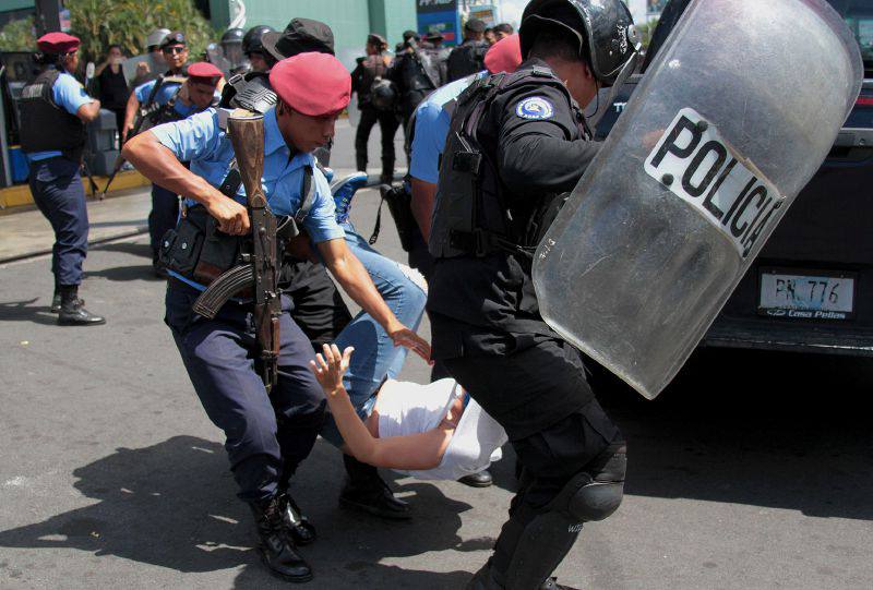 policías agrediendo a universitario por participar en manifestaciones pasivas. 